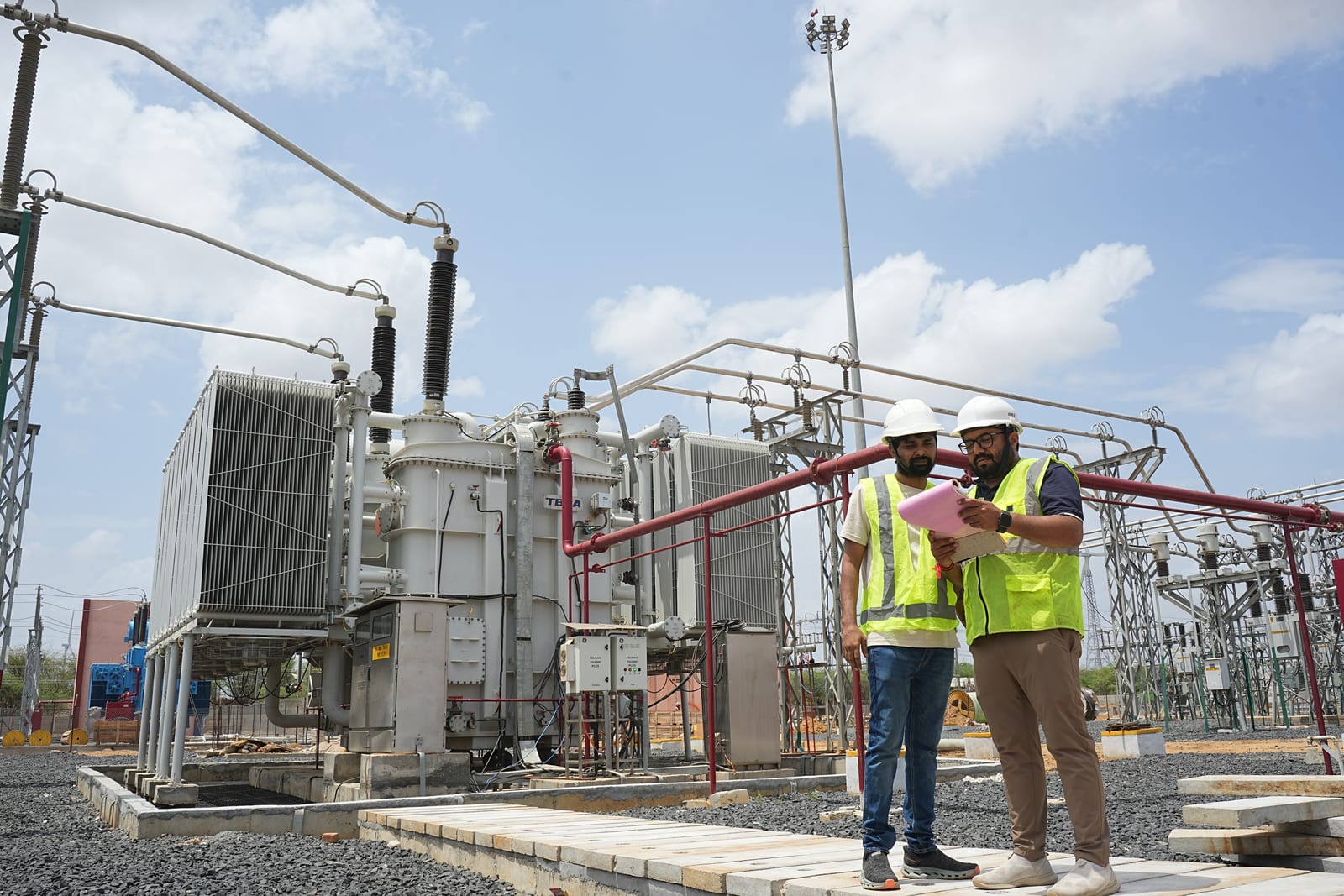 Engineers inspecting a substation transformer during operation and maintenance